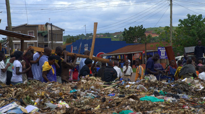 The Way of the Cross procession passes by and through a rubbish dump in Mbikko, Uganda