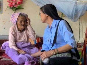 Sister Regina in Myanmar comforts an elderly woman